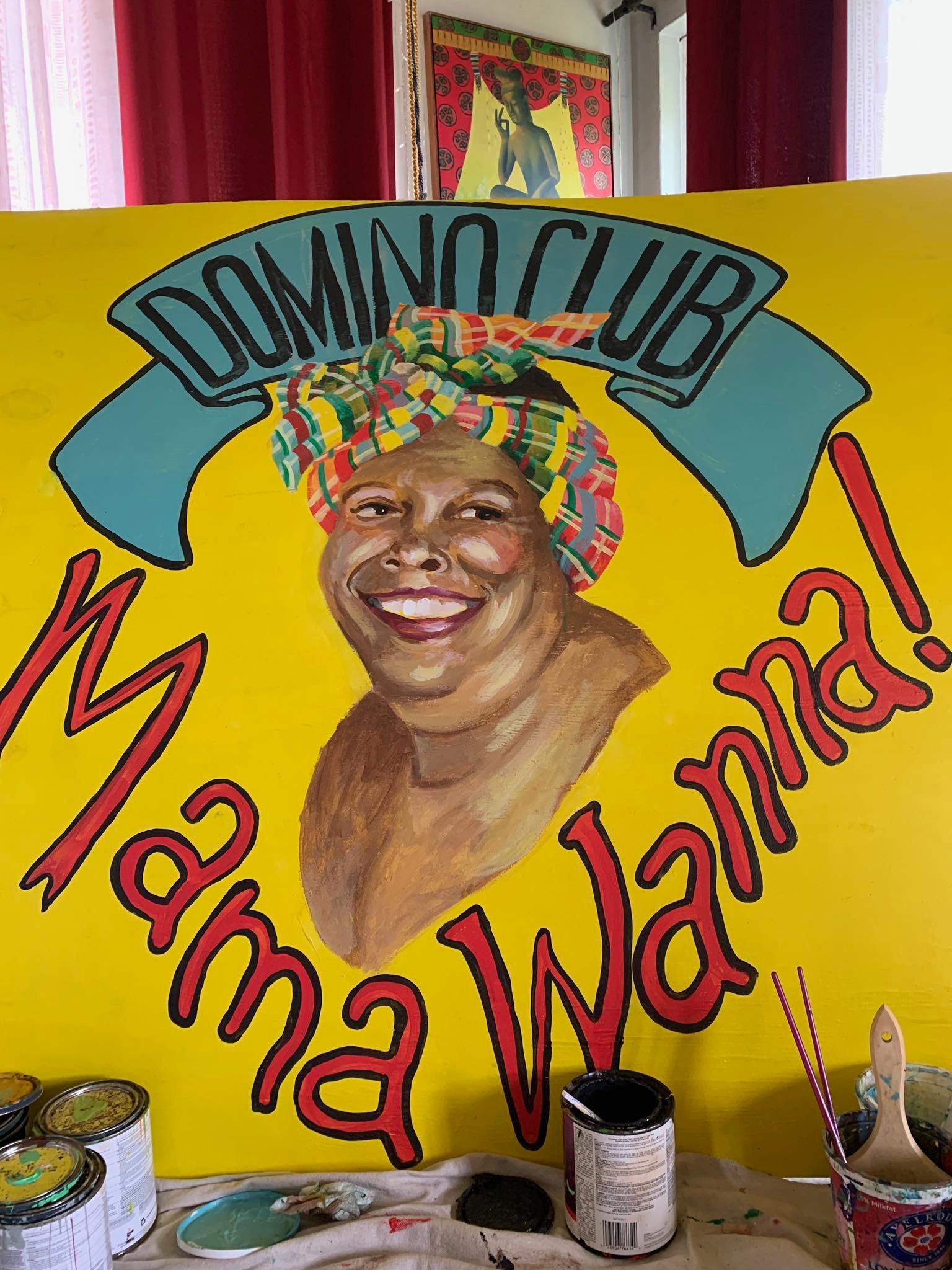 Hand-painted portrait of Norma George wearing a colorful kente cloth headwrap, smiling warmly, with 'Domino Club' banner above and 'Mama Wanna!' painted in red below
