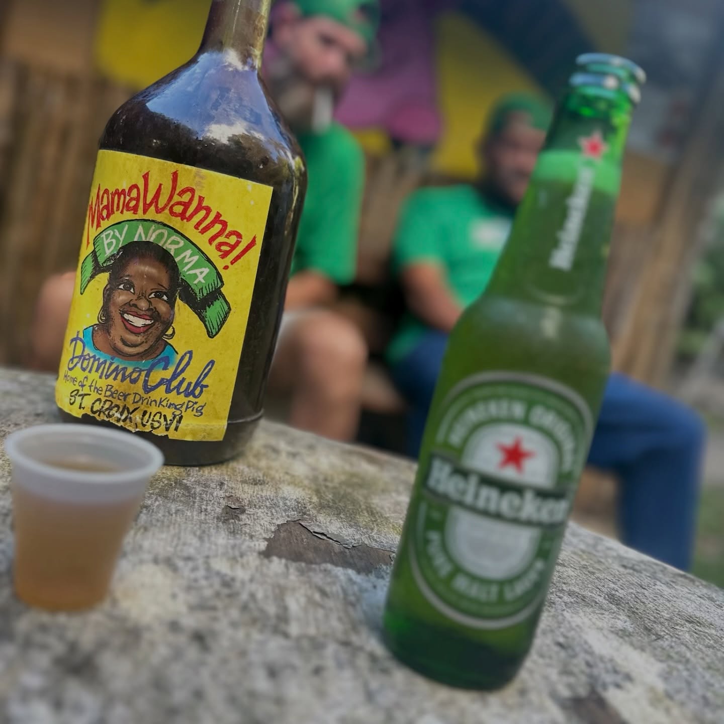 Three women laughing and holding colorful drinks at the Domino Club entrance
